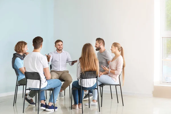 Jonge mensen met psycholoog tijdens groepstherapie sessie — Stockfoto
