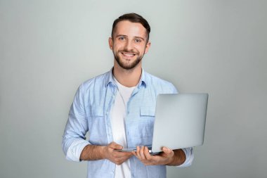 Hafif arka planda dizüstü bilgisayar ile Yakışıklı adam