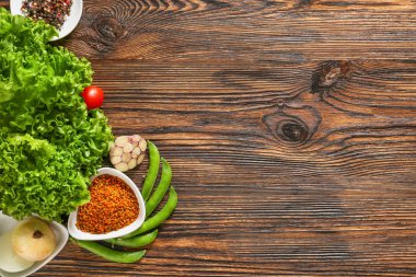 Tahta arka planda taze sebze ve baharatlar.
