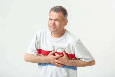 Beyaz arka planda kalp krizi muzdarip olgun adam