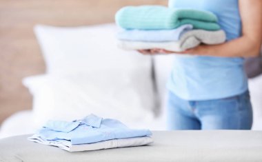 Evde ütü tahtası üzerinde temiz giysiler