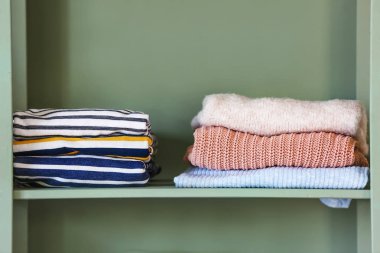 Renkli arka planda temiz giysi yığınları ile Raf