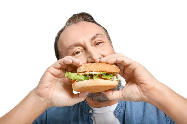 Portrait de bel homme mature avec hamburger savoureux sur fond blanc — Photo