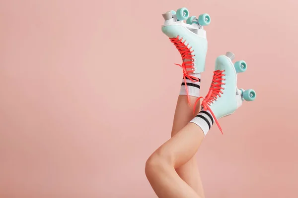 色の背景にヴィンテージローラースケートの女性の足 — ストック写真