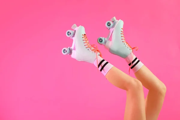 Benen van de vrouw in rolschaatsen op kleur achtergrond — Stockfoto