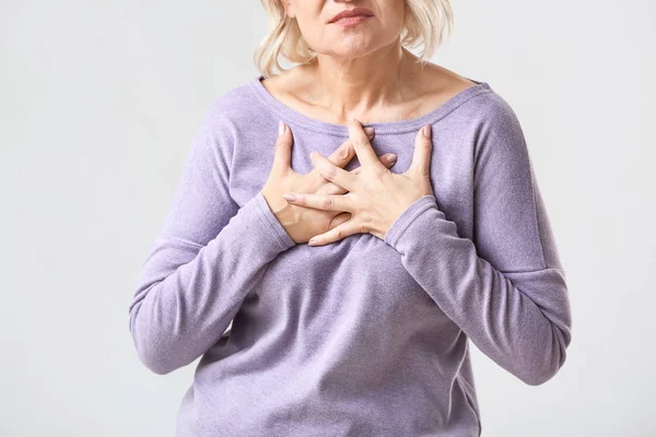 Mature woman suffering from heart attack on white background — Stock Photo, Image