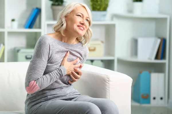 Mature woman suffering from heart attack at home — Stock Photo, Image