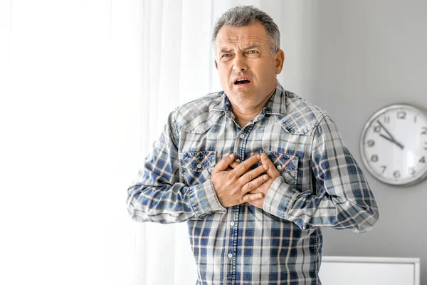 Mature man suffering from heart attack at home — Stock Photo, Image