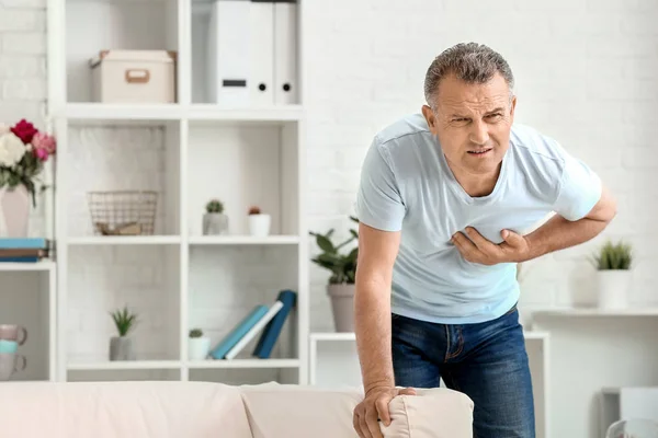 Mature man suffering from heart attack at home — Stock Photo, Image
