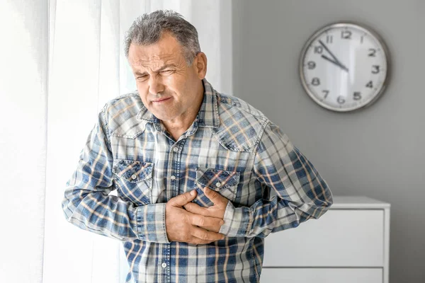 Zralý muž trpí srdeční infarkt doma — Stock fotografie