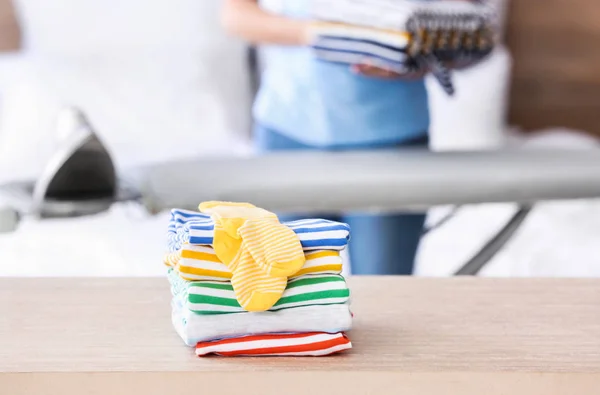 Stack of clean clothes on table at home — Stock Photo, Image