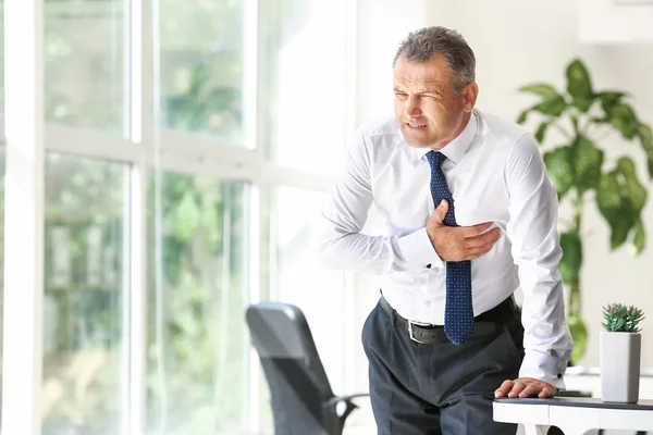 Mature man suffering from heart attack in office — Stock Photo, Image