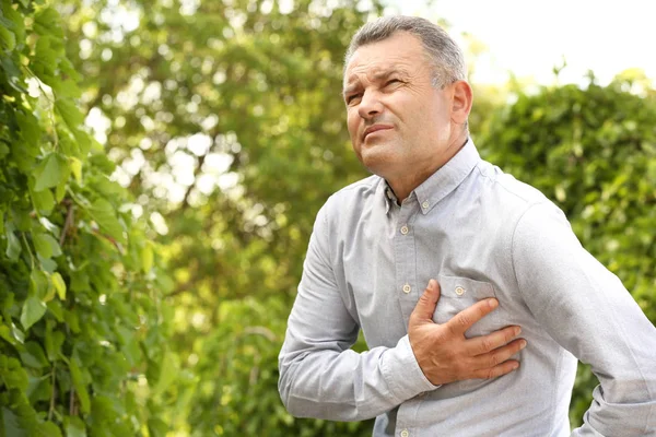 Mature man suffering from heart attack outdoors — Stock Photo, Image