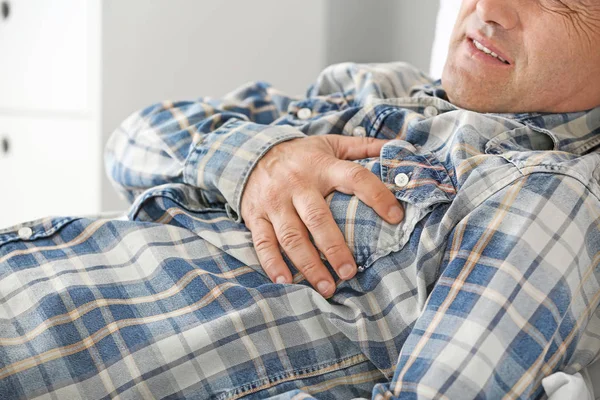 Mature man suffering from heart attack at home, closeup — Stock Photo, Image