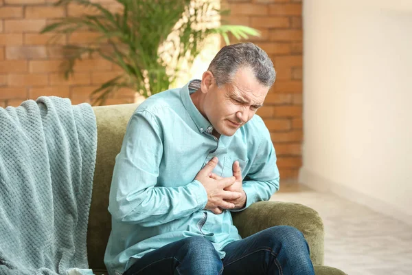 Mature man suffering from heart attack at home — Stock Photo, Image