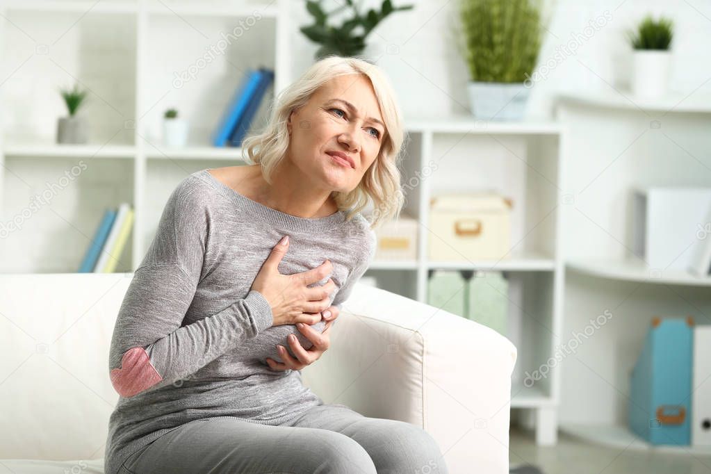 Mature woman suffering from heart attack at home