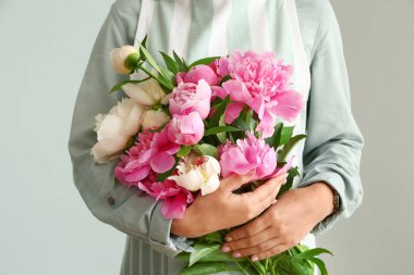 Gri arka planda şakayık güzel buket ile Kadın çiçekçi