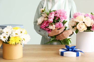 Gri arka planda şakayık güzel buket ile Kadın çiçekçi