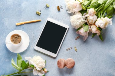 Tablet bilgisayar ve renkli arka planda kahve fincan ile güzel şakayık