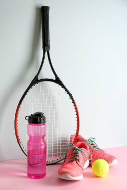 Tenis raket, top, hafif arka plan üzerinde su ve ayakkabı şişesi