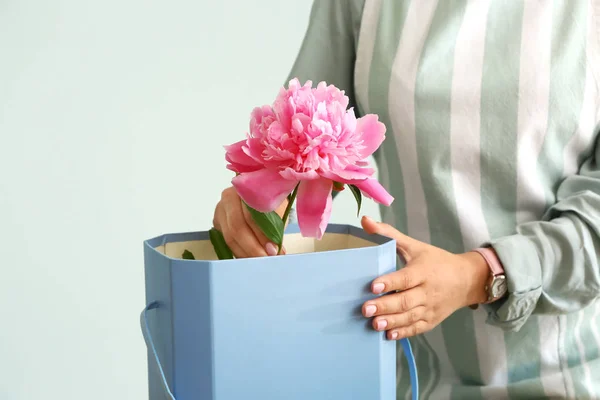 Female florist working with beautiful peonies on grey background — Stock Photo, Image