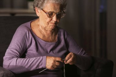 Yaşlı kadın akşam geç saatlerde evde örgü