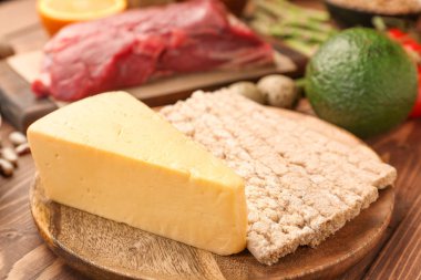 Ahşap masa üzerinde peynir ve gevrek ekmek ile Tabak