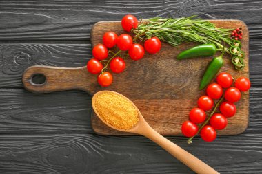 Koyu ahşap masada baharat, taze sebze ve biberiye ile Kurulu