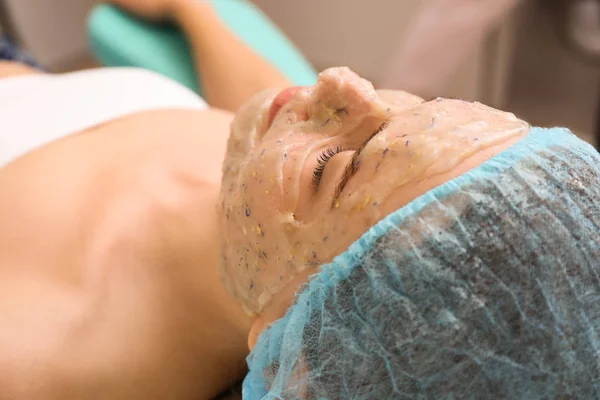 Красивая женщина проходит процедуру с маской для лица в салоне красоты — стоковое фото
