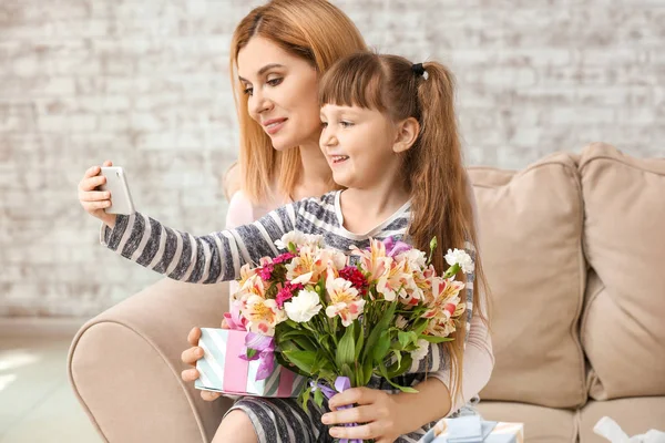 Woman taking selfie with her little daughter and gifts for Mother's Day — Stock Photo, Image