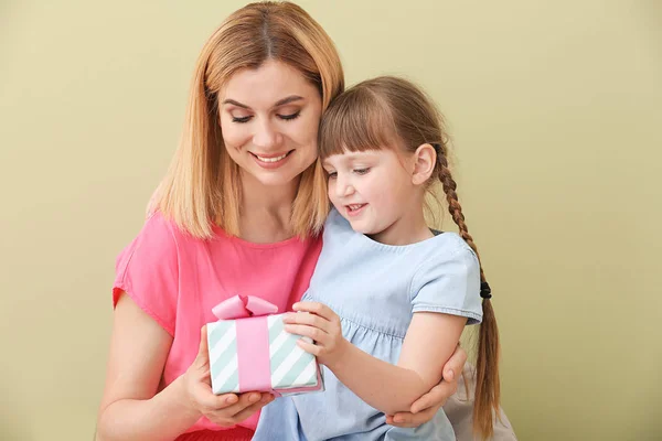 Little girl greeting her mother on color background — Stock Photo, Image