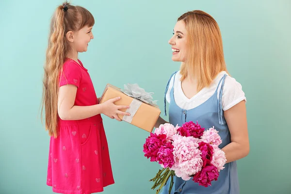 Klein meisje groet haar moeder op kleur achtergrond — Stockfoto
