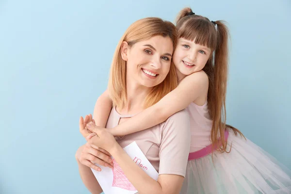 Little girl greeting her mother on color background — Stock Photo, Image