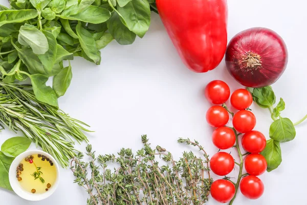 Frame made of fresh herbs with vegetables, oil and spices on light background