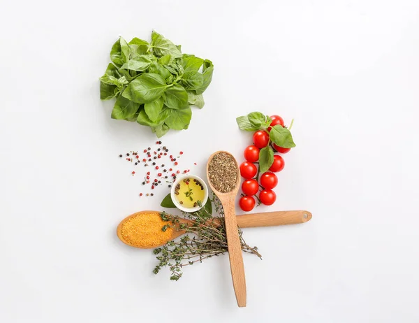 Fresh herbs with tomatoes, oil and spices on light background — Stock Photo, Image
