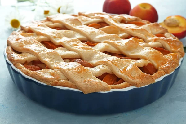 Tasty peach pie on color background, closeup