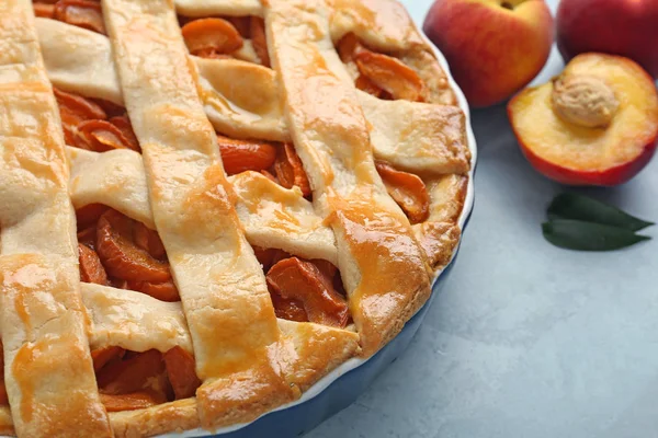 Tasty peach pie on color background, closeup