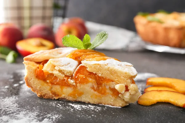 Шматочок смачного персикового пирога на тарілці з шиферу — стокове фото