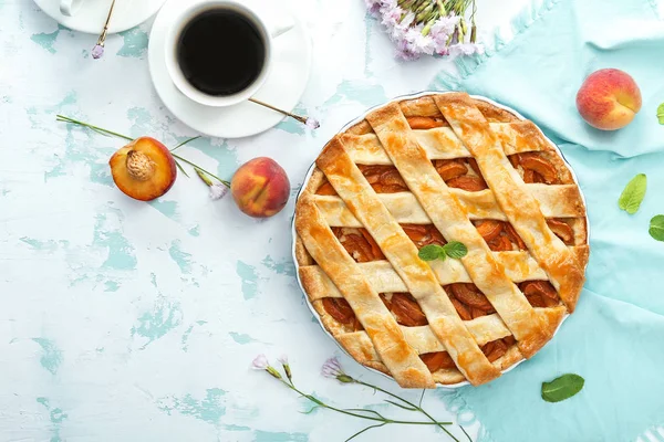 Tasty peach pie and cup of coffee on table