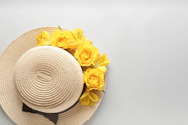 Hermosas flores y sombrero sobre fondo claro — Foto de Stock