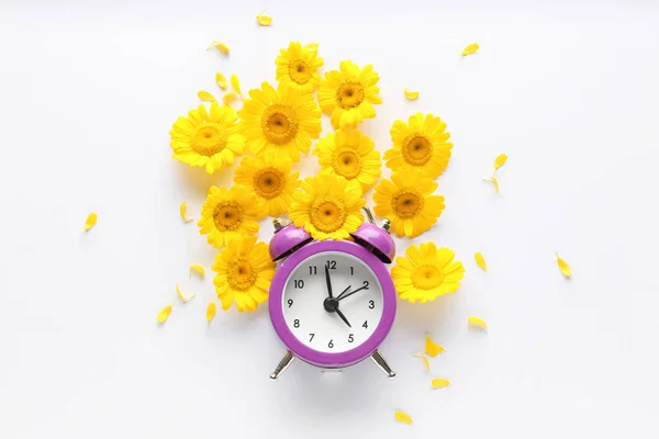 Beautiful composition with flowers and alarm clock on white background — Stock Photo, Image