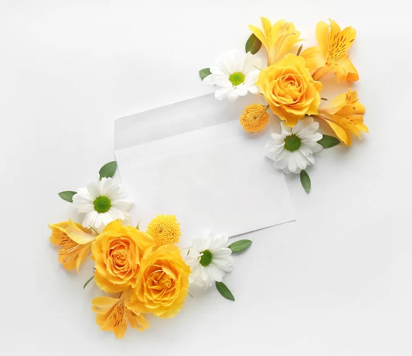 Vacker komposition med blommor och kuvert på vit bakgrund — Stockfoto