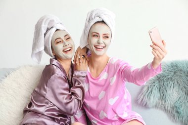 Evde selfie çeken yüz maskeli güzel genç kadınlar