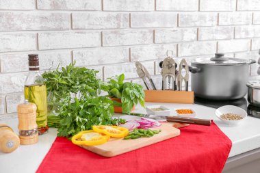 Mutfakta masada taze otlar, sebzeler, yağ ve baharatlar ile kesme tahtası