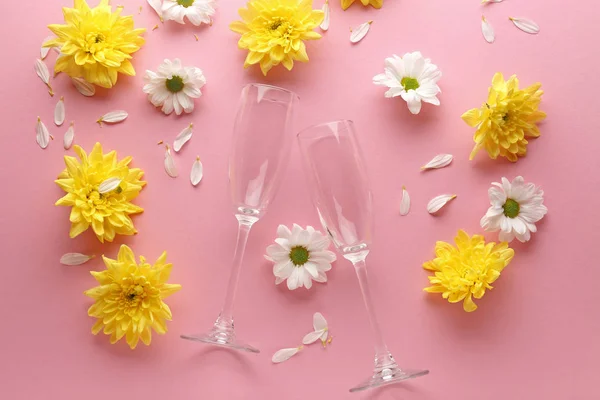 Composition with empty glasses and beautiful flowers on color background — Stock Photo, Image