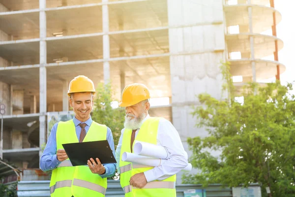 Arquitetos discutindo projeto de construção ao ar livre — Fotografia de Stock