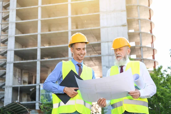 Arquitectos discutiendo proyecto de construcción al aire libre —  Fotos de Stock