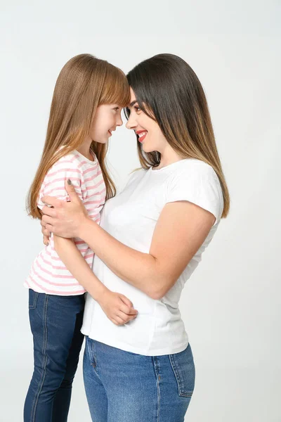 Portrait of happy mother and daughter on light background — Stock Photo, Image