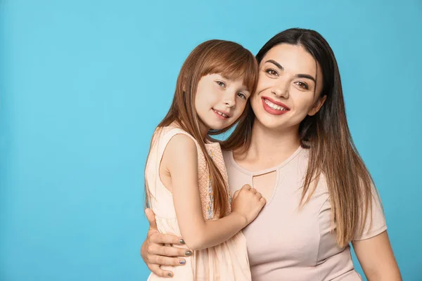 Portrait of happy mother and daughter on color background — Stock Photo, Image