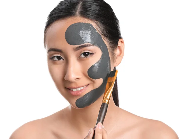 Schöne asiatische Frau mit Gesichtsmaske auf weißem Hintergrund — Stockfoto